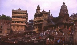 ManikarnikaGhat from the Ganges.  The terraced buildings to the left and center are pilgrim sheds.  The domed temple to the right, now abandoned, was built in the 18th century by Queen Ahalya Bai Holkar of Indore