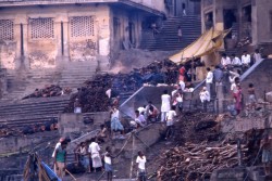 Wood is piled for cremations on the center steps of Manikarnika while families and mourners prepare for the rituals